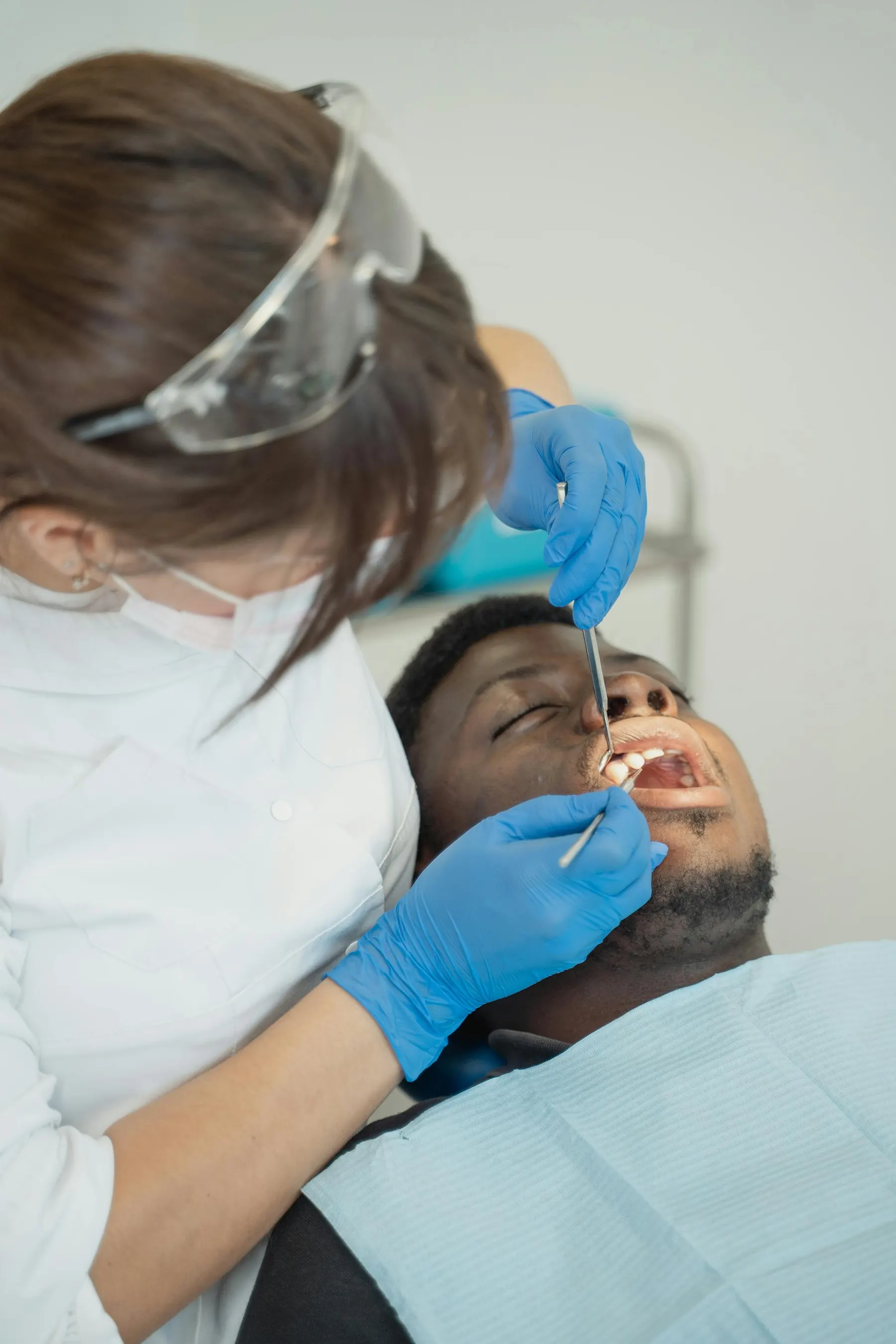 A professional dental cleaning in progress under warm operatory light