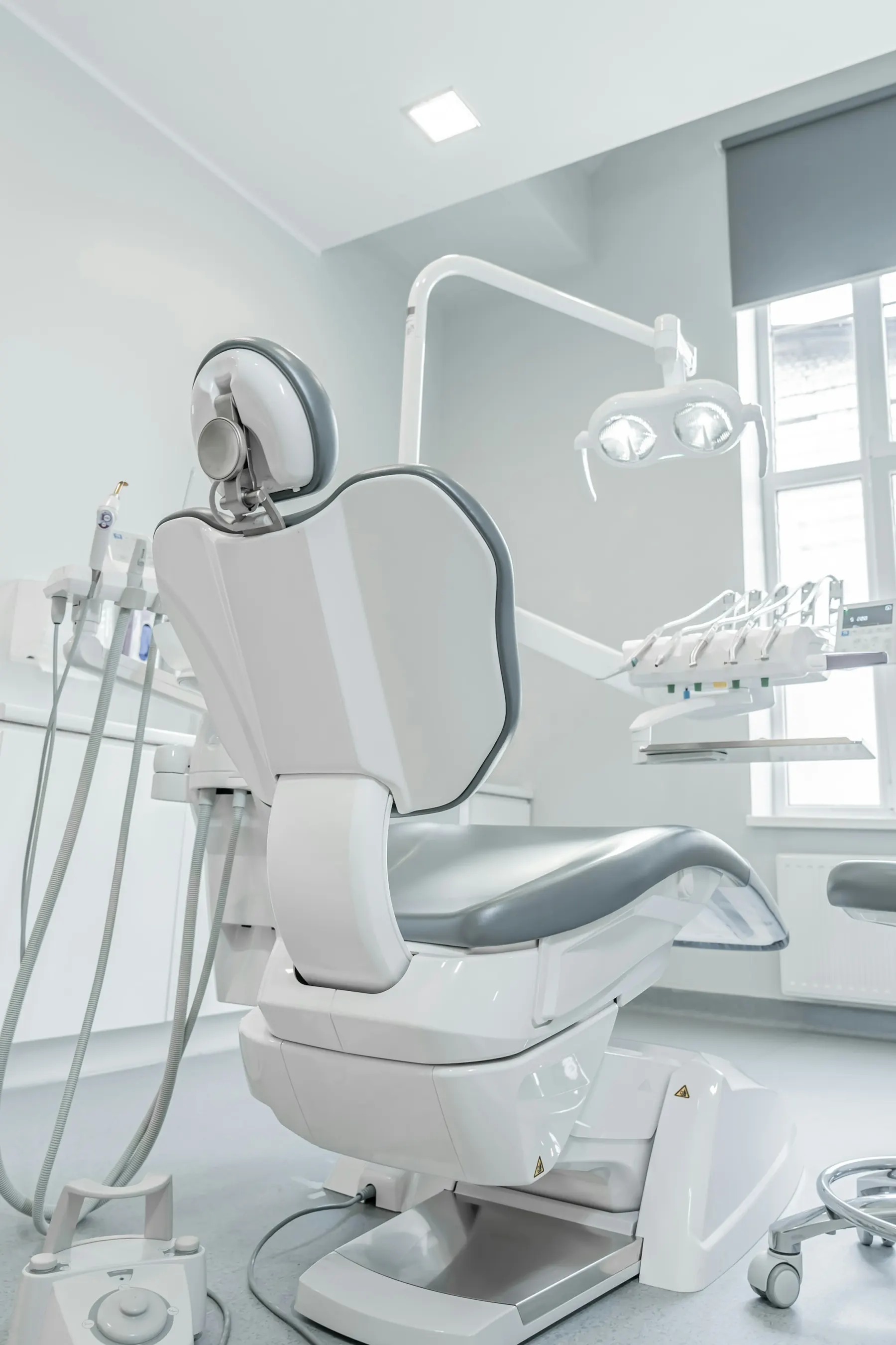 Modern white dental chair in a sunlit operatory